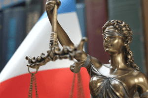 Statue en bronze représantant la justice et drapeau français en arrière plan