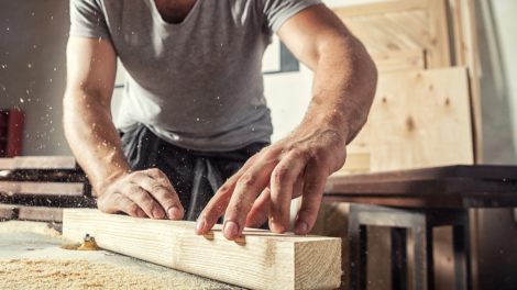 Menuisier dans un atelier travaille sur une pièce pour un meuble en bois