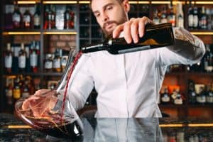 Oenologue met en carafe un vin rouge