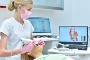 Orthodontiste réalise une prise d'empreintes en 3D des dents d'une patiente