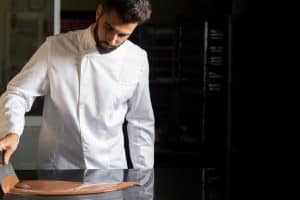 Chef patissier travaille du chocolat dans son laboratoire