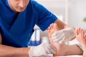 Podologue s'occupe des pieds d'un patient