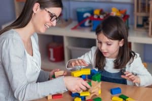 Animatrice socioculturel qui joue avec une enfant dans une centre de loisirs