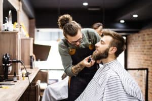 Barbier qui coupe la barbe d'un client