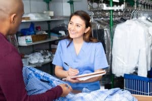 Blanchisseuse récéptionne les vêtements d'un client