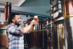 Brasseur vérifie la qualité de la bière sortie des cuves