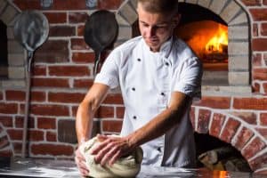 Pizzaiolo qui fabrique une pâte à pizzas