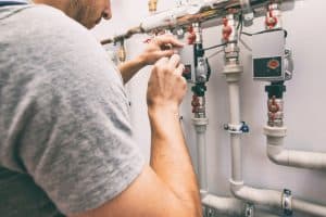 Chauffagiste réalise la maintenance d'un réseau de chauffage