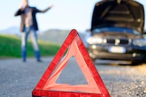 Homme en panne avec sa voiture au bord de la route
