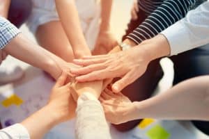 Plusieurs personnes posent leurs mains les unes sur les autres