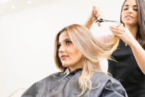 Coiffeuse qui coupe les cheveux d'une cliente