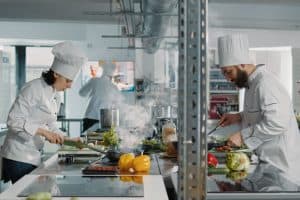 Commis et chef dans la cuisine d'un restaurant