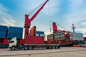 Déchargement d'un contrainaire sur un camion de transport de marchandises