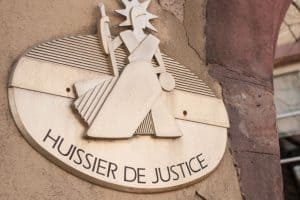 Plaque d'huissier de justice sur un immeuble