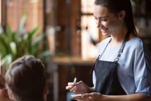 Serveuse qui prend la commande de clients