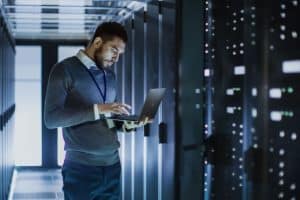 Administrateur systèmes dans une salle de serveurs informatiques