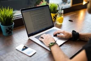 Copywriter qui rédige un texte sur ordinateur