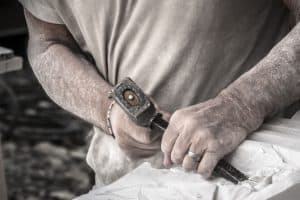 Taille d'un bloc de pierre avec un marteau et un burin
